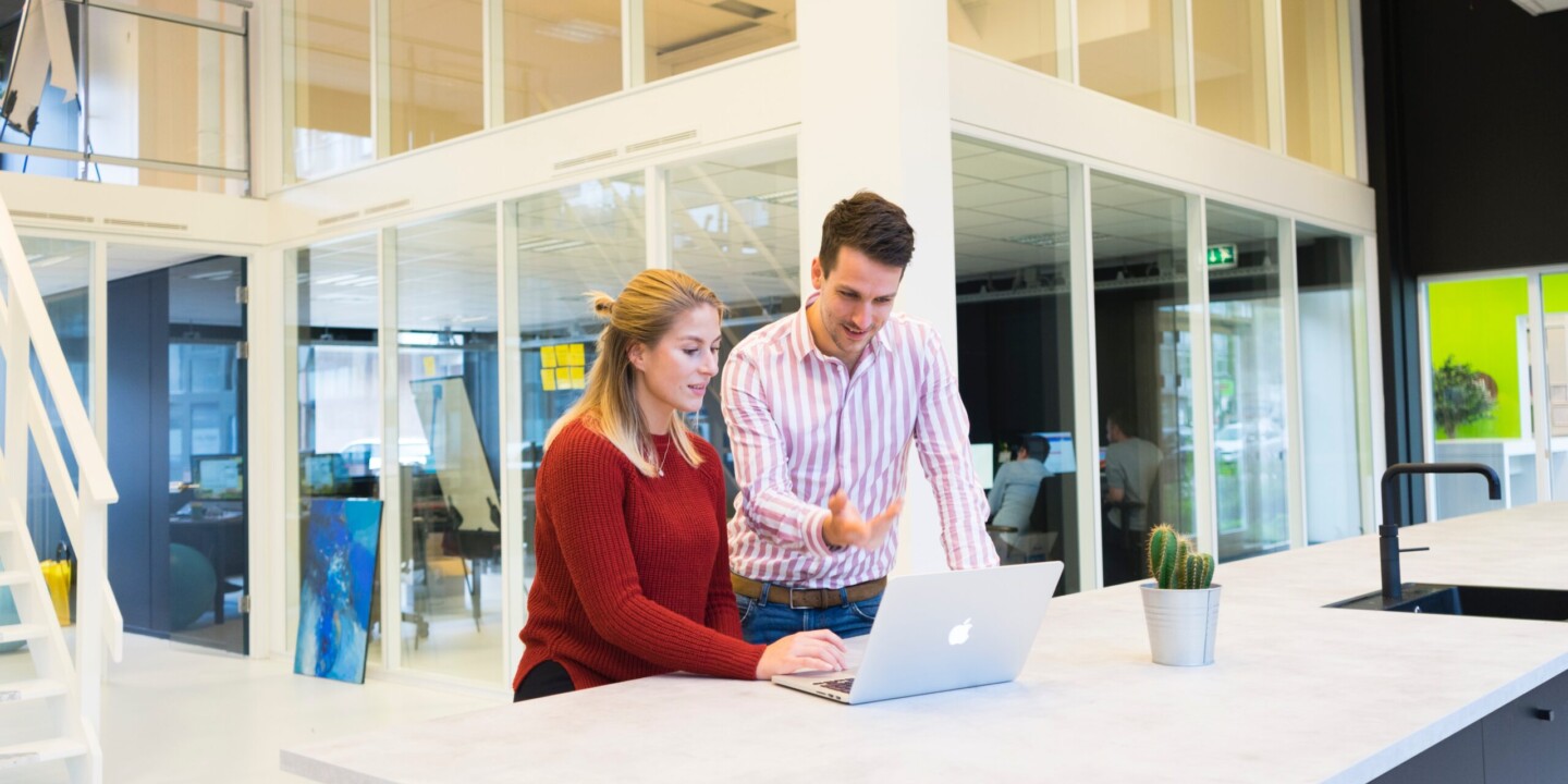 Man talking to a girl while looking on a laptop